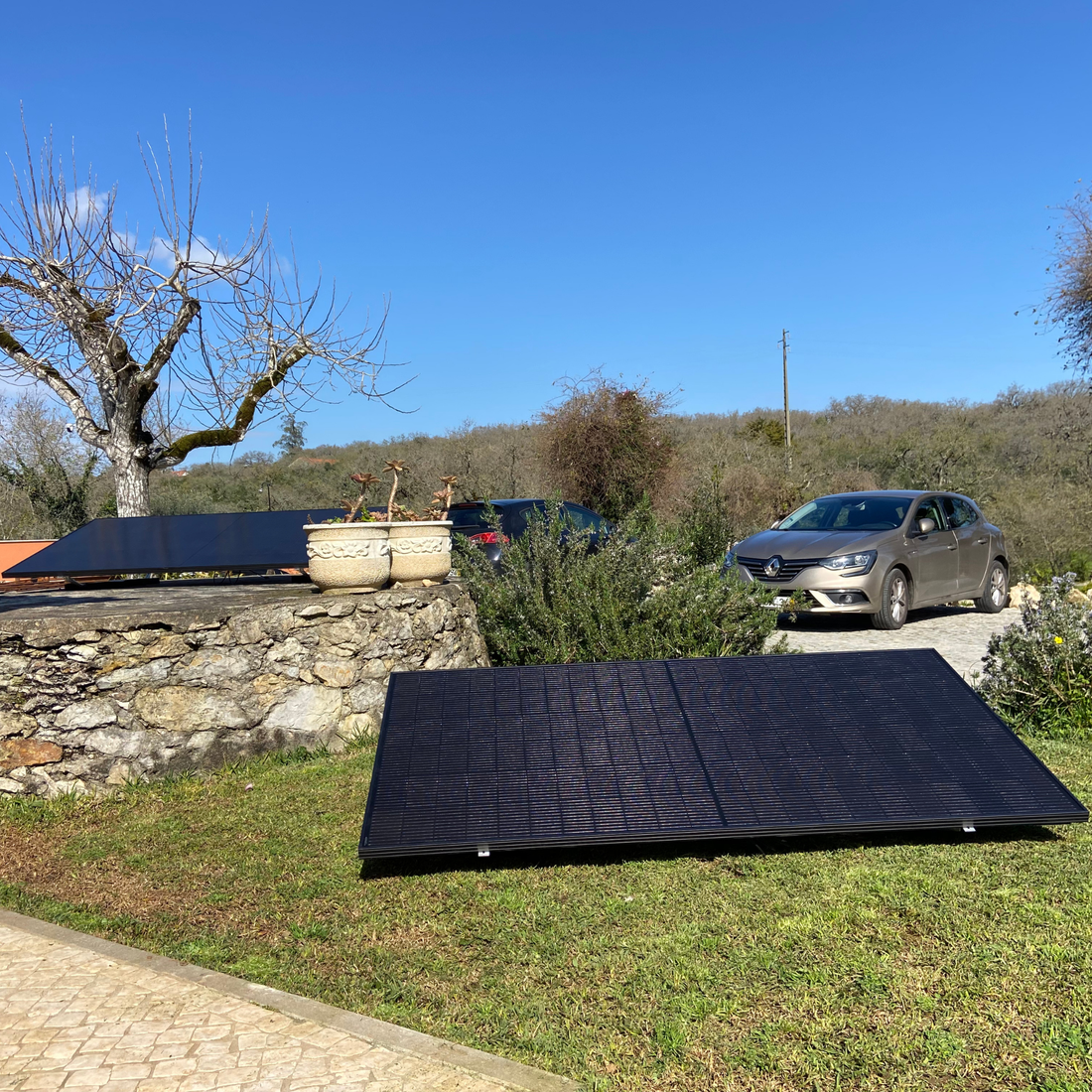Kit solar de dois painéis montado no jardim de uma moradia