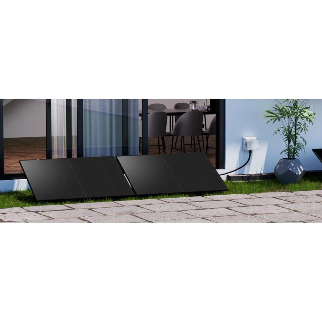 Kit solar de dois painéis montado no solo junto a uma casa